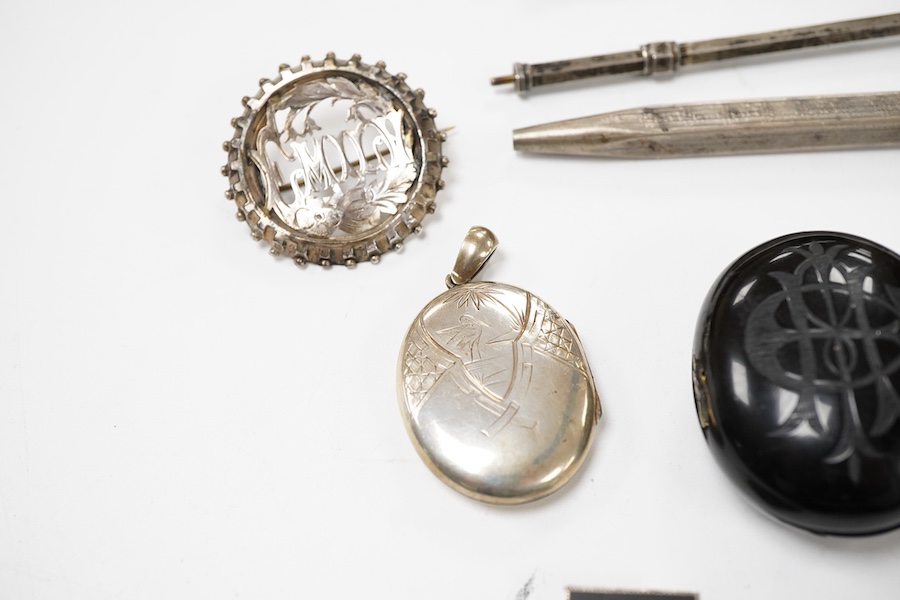 A group of jewellery, comprising: a locket, possibly in jet or bog oak, bearing the initials CIM, the interior with two compartments, length 4.6cm, design registration mark for circa 1861, maker's mark; three mechanical